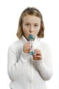 Girl with asthma blows into a peak flow meter.